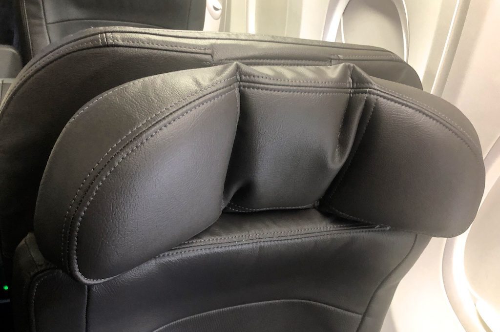 Folded neck support on first class seat