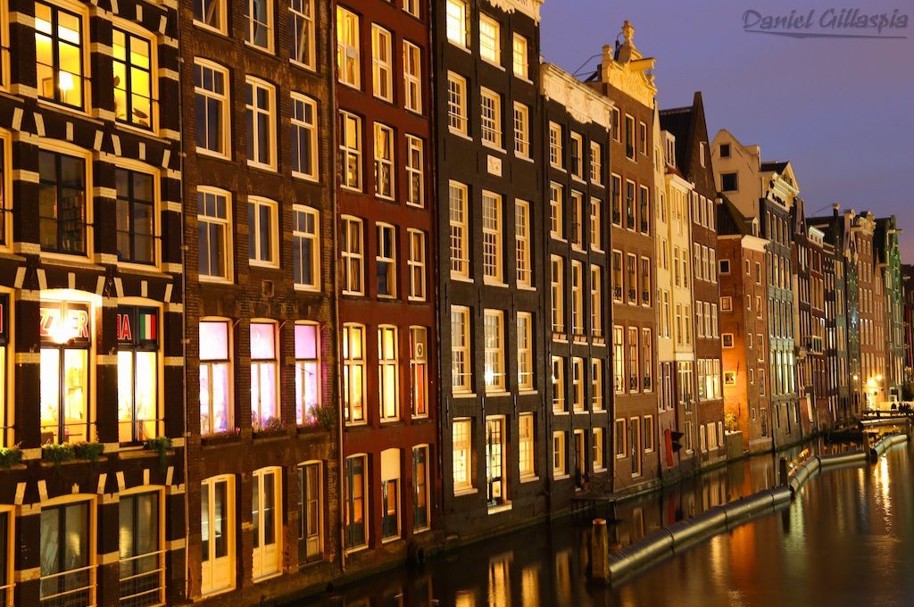 Buildings line canal in Amsterdam at night