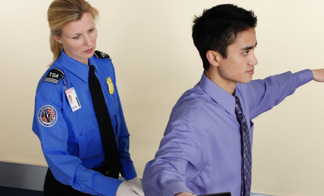 TSA agent searching a man