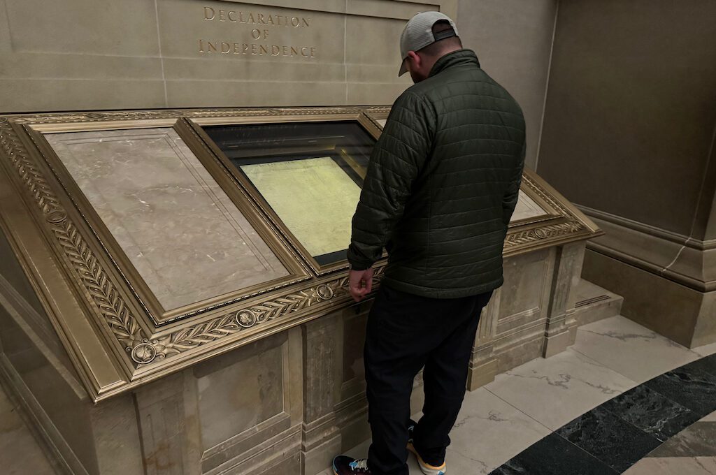 man in National Archives Museum rotunda viewing declaration of independence