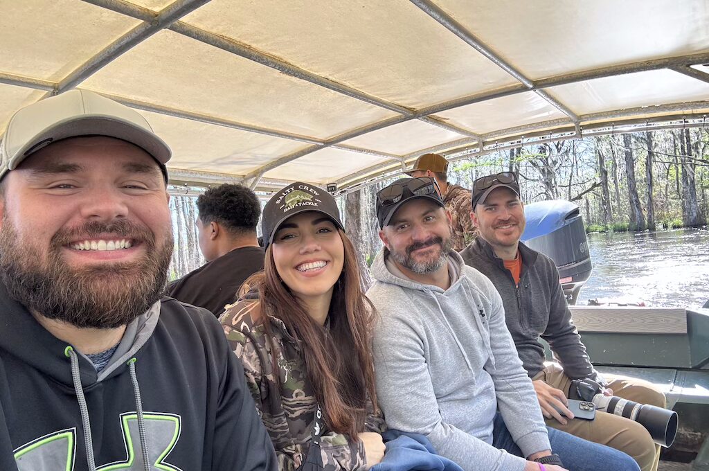 Three men and a woman in swamp boat tour