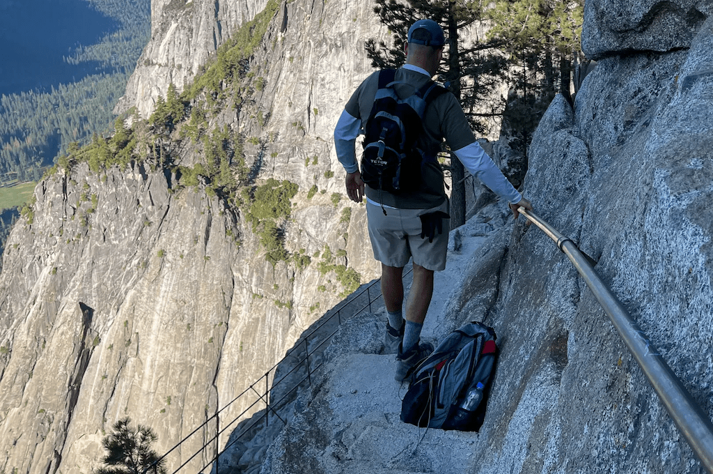 Man walking down side of mountain