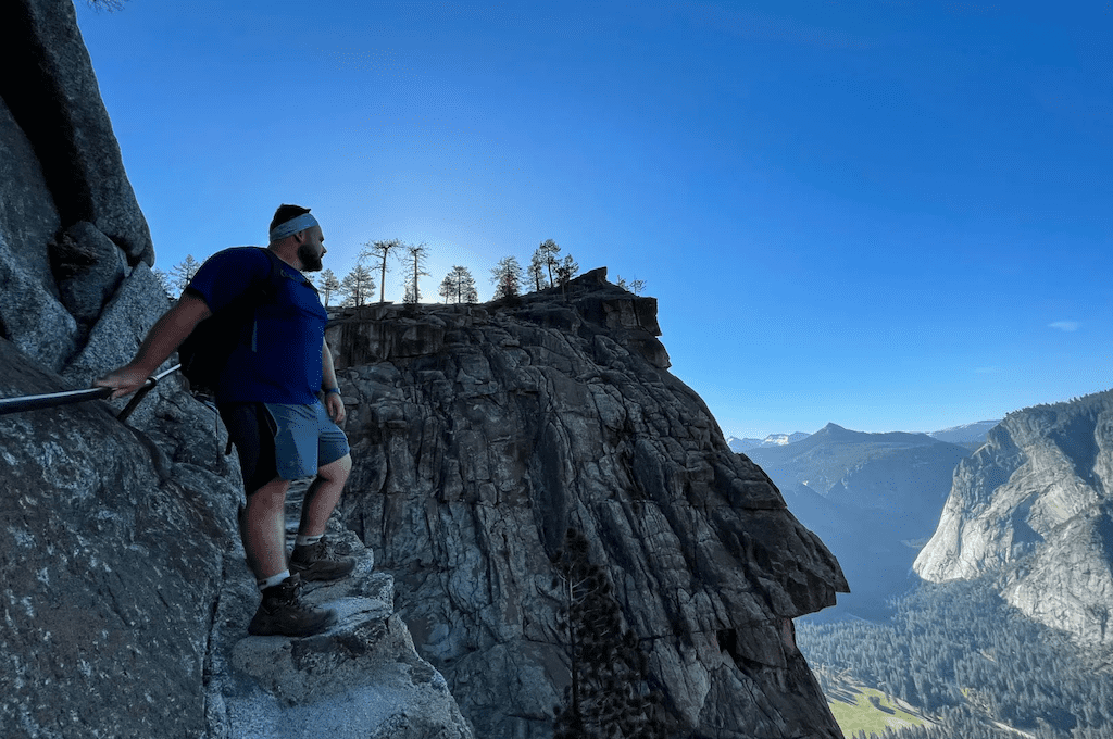 Man looking out at valley on rocky trail