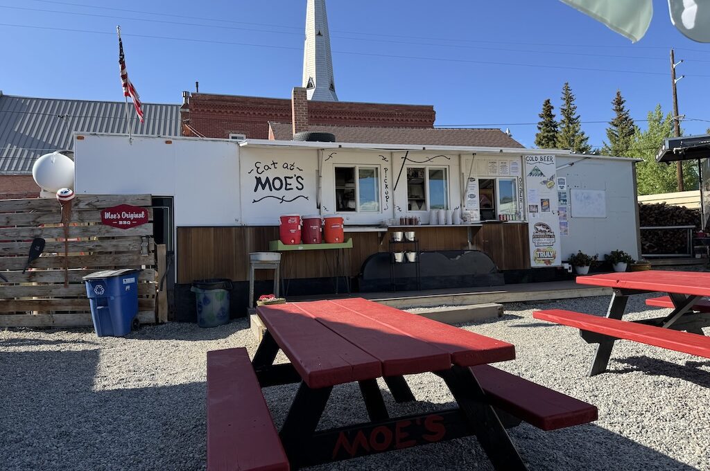 Food trailer with red picnic tables out front