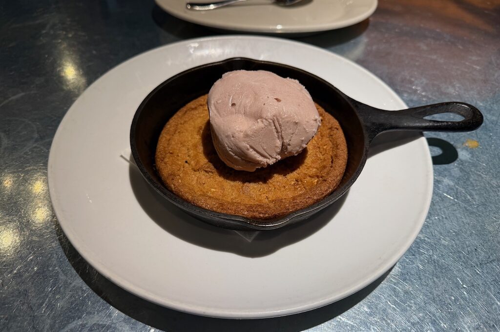 Small cast iron skillet with cookie inside and scoop ice cream on top
